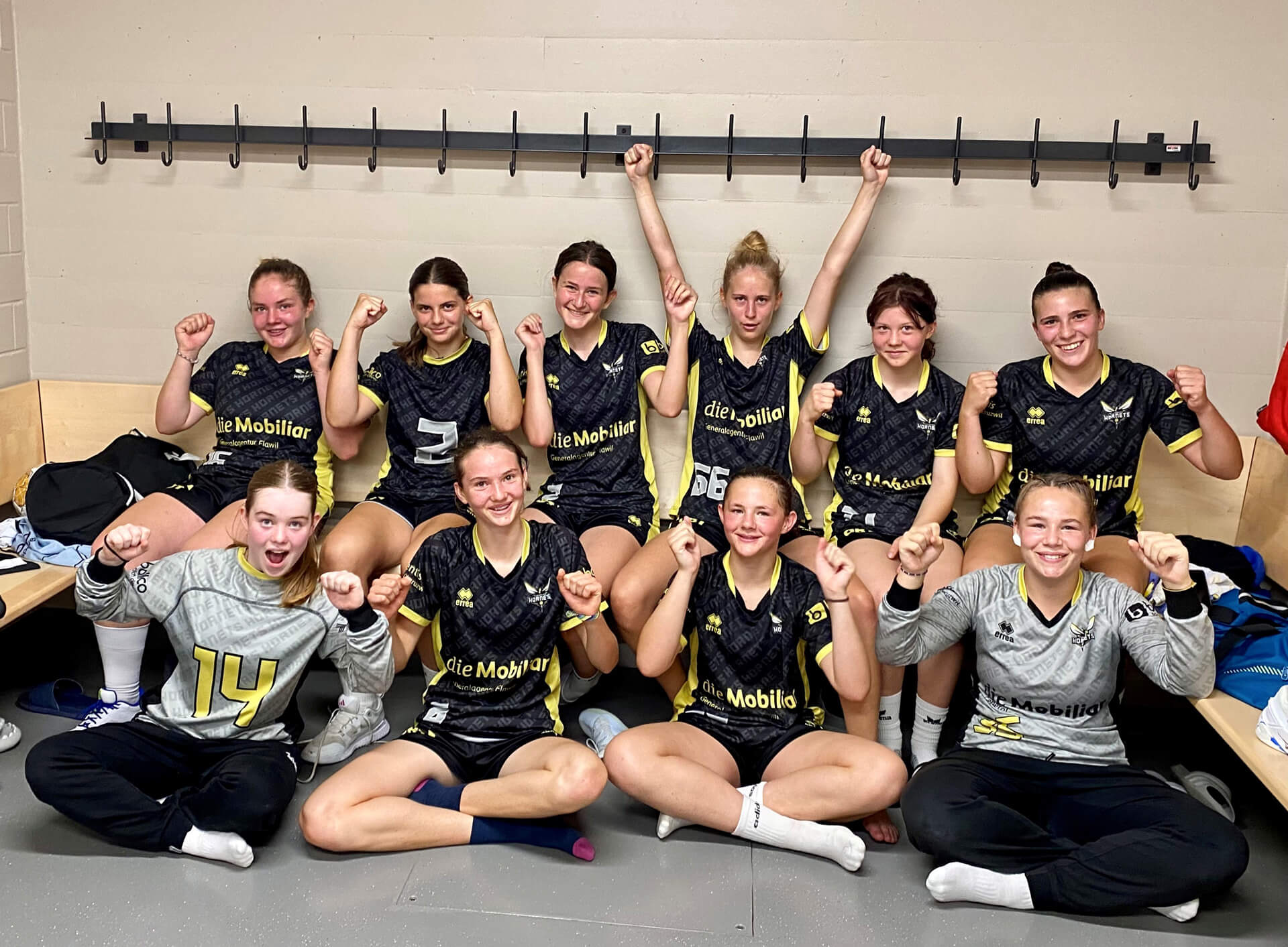 Eine Gruppe Frauen posiert in einer Umkleidekabine für das Siegerfoto.