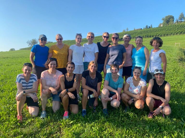 Eine Gruppe von Frauen posiert auf einer Wiese für ein Foto.