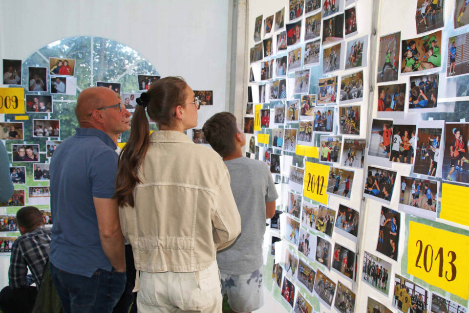 Besucher schauen Galeriewand am Jubiläum an.